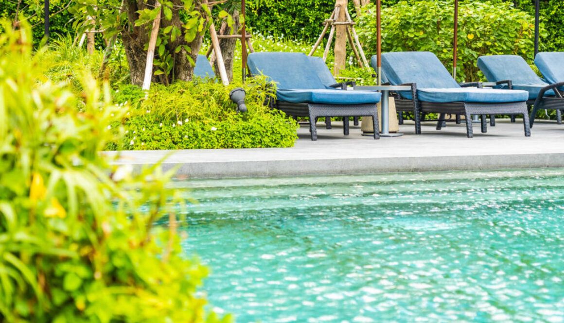 Beautiful outdoor swimming pool in hotel and resort with chair a