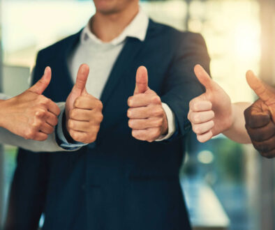 Youre our most valued employee. Cropped shot of a group of businesspeople giving thumbs up in a modern office.