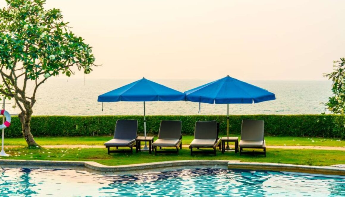 beach-chair-pool-bed-with-umbrella-around-swimming-pool-with-sunset-sea_0x800