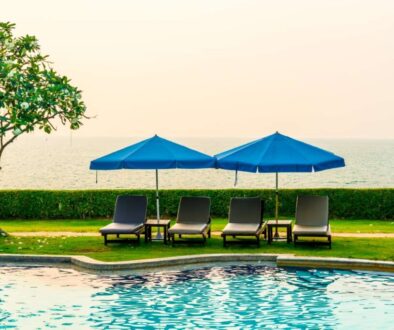 beach-chair-pool-bed-with-umbrella-around-swimming-pool-with-sunset-sea_0x800