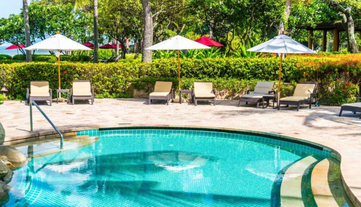 beautiful-tropical-beach-sea-with-umbrella-chair-around-swimming-pool-hotel-resort_0x800