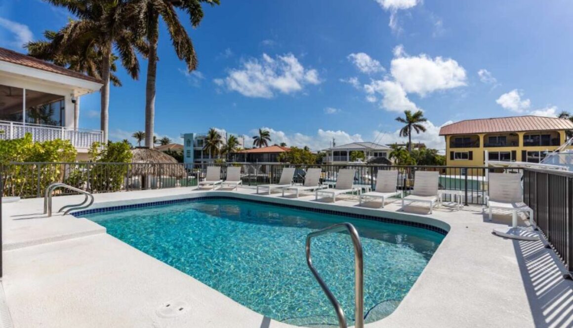 modern-building-with-swimming-pool-trees-chairs-landscape-with-blue-sky-scenic-enviroment_0x800